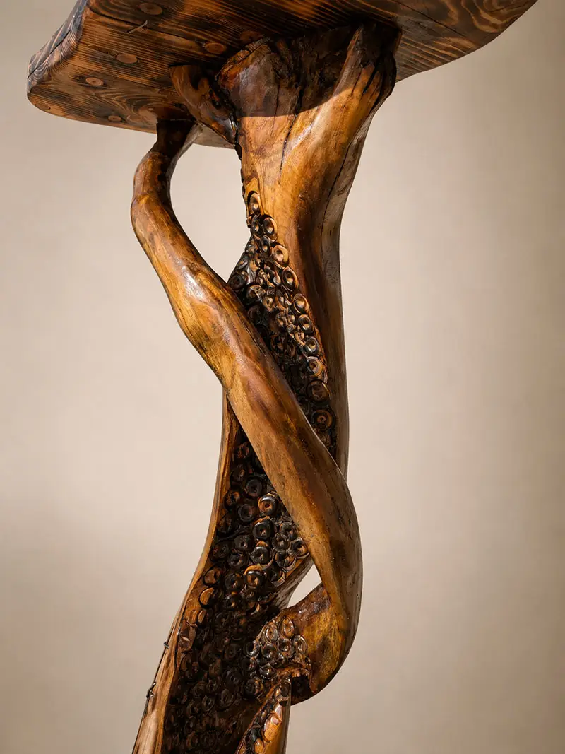 Detail van handgemaakte houten bijzettafel met organische sculptuur en houtstructuur